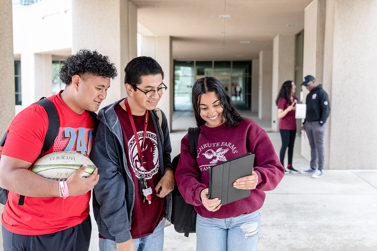 Norco College students on campus looking at tablet
