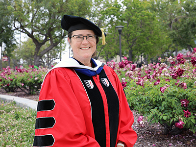 Professor Sarah Burnett on Norco College campus in commencement regalia
